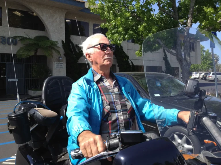An older gentleman on a motorcycle wearing bioptic telescope glasses